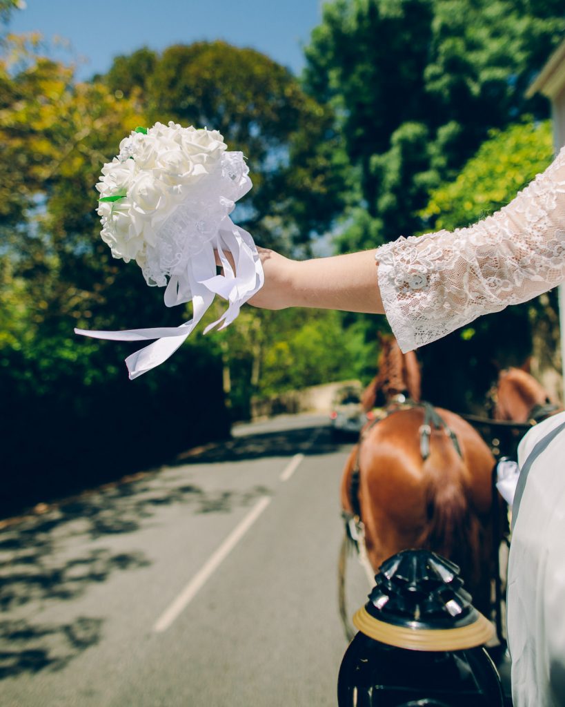 Elopement Casamento Sintra-Lisboa Noiva segurando seu bouquet em cima de uma carroça