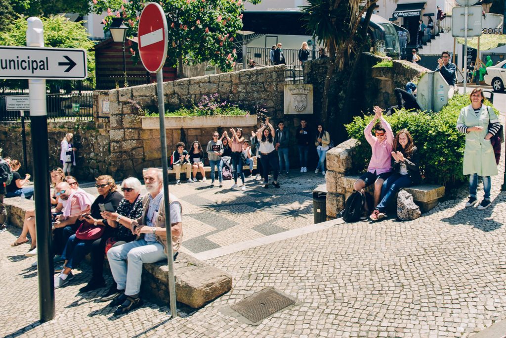 Elopement Casamento Sintra-Lisboa pessoas nas ruas cumprimentando aos noivos que passeiam pelas ruas