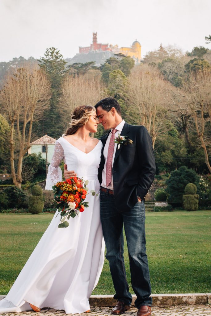 casal encostado testa com testa com o fundo do palácio da Pena no fundo