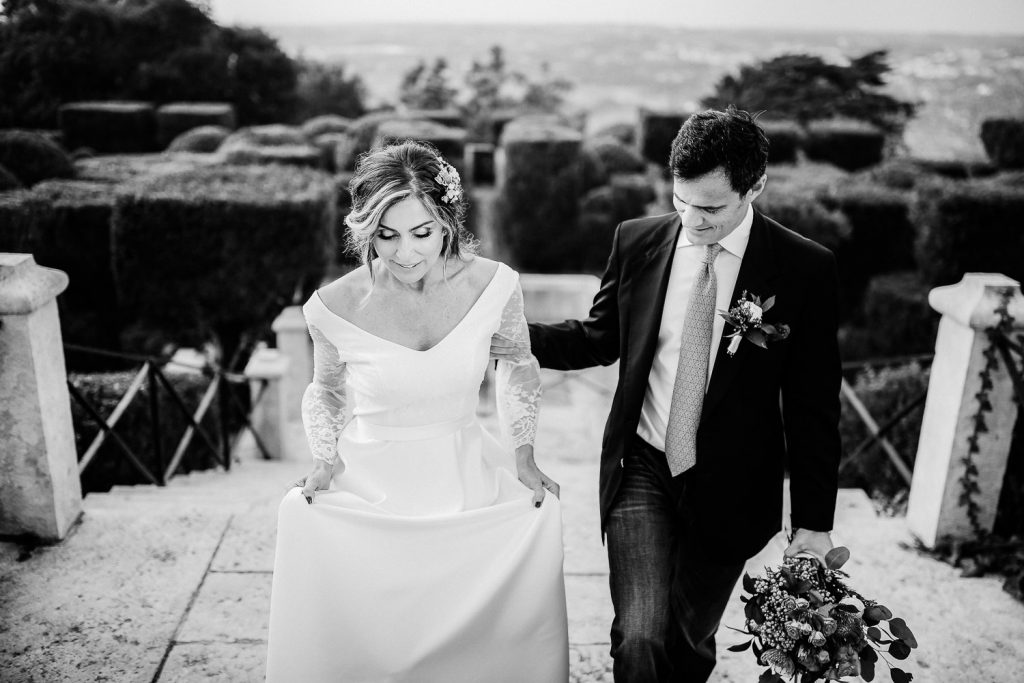 noivos em tom cinza andando pela escada de fora