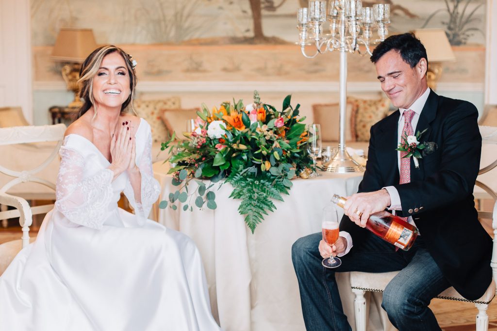 noivo abrindo o champagne e a noiva batendo palma