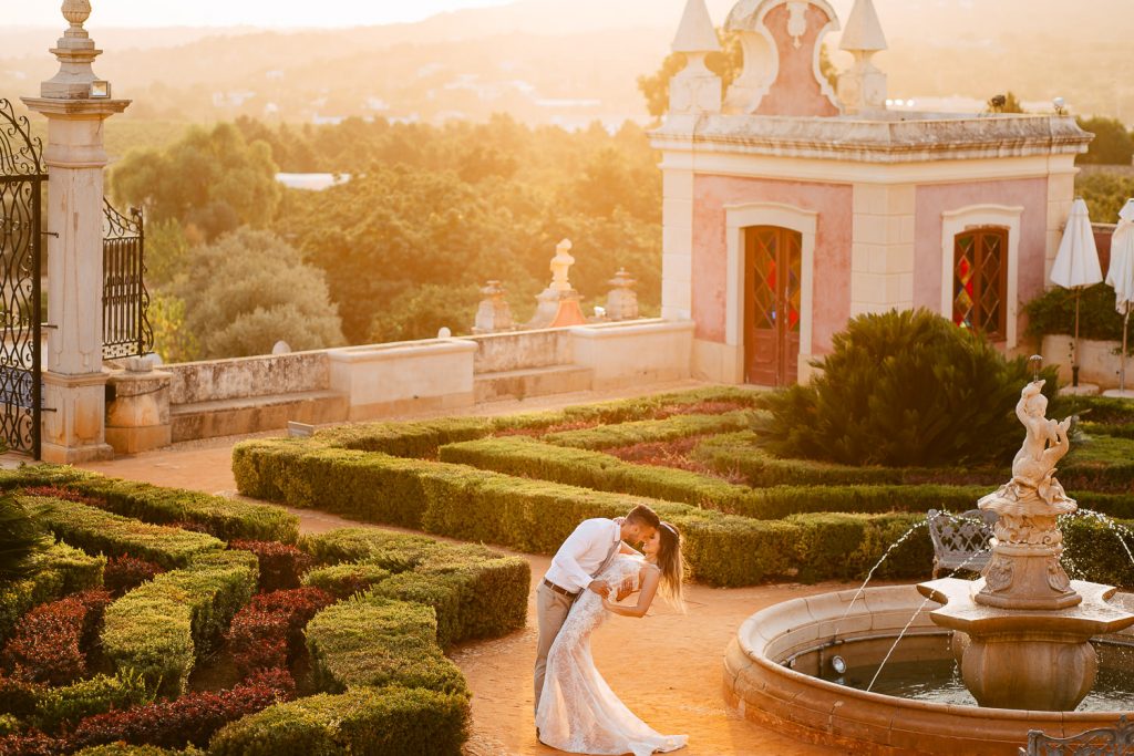 destination wedding palácio estoi casal de noivos no jardim no pôr do sol