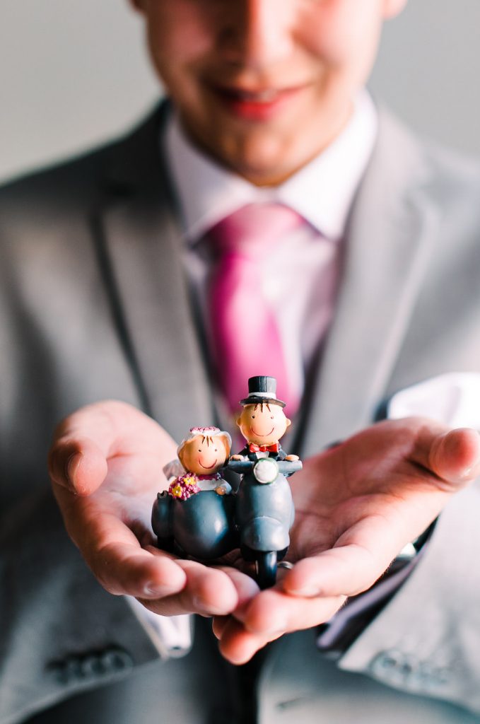 Destination Wedding Madrid Espanha noivo segurando uma miniatura de uns bonecos que estão na motocicleta