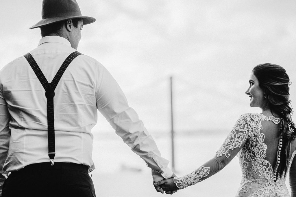 Elopement Alma lisboeta em Lisboa noivos andando das mãos dadas com a ponte 25 de Abril no fundo