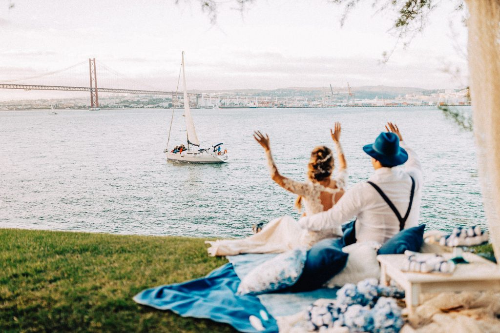 Elopement Alma lisboeta em Lisboa casal dando um olá para um barco no rio Tejo