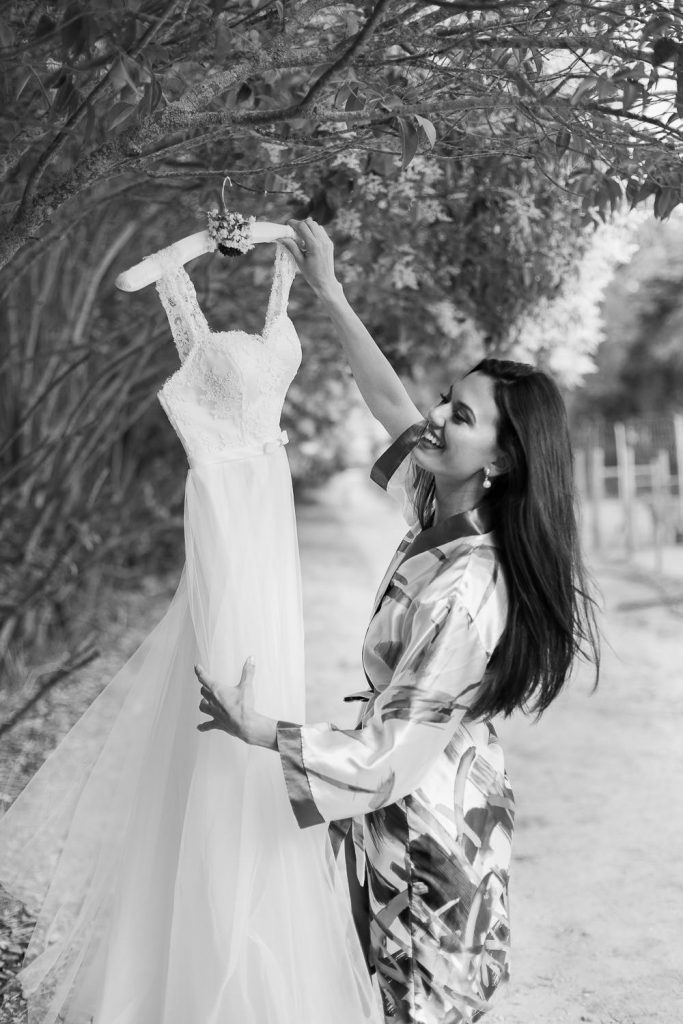 elopement boho quinta de alcube noiva segurando o vestido e se arrumando, making of da noiva em um vinhedo de Portugal