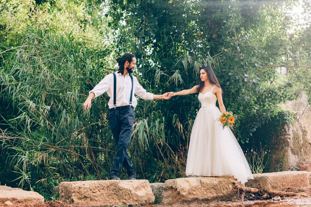 elopement boho quinta de alcube noivos atravessando um riacho por uma sítio