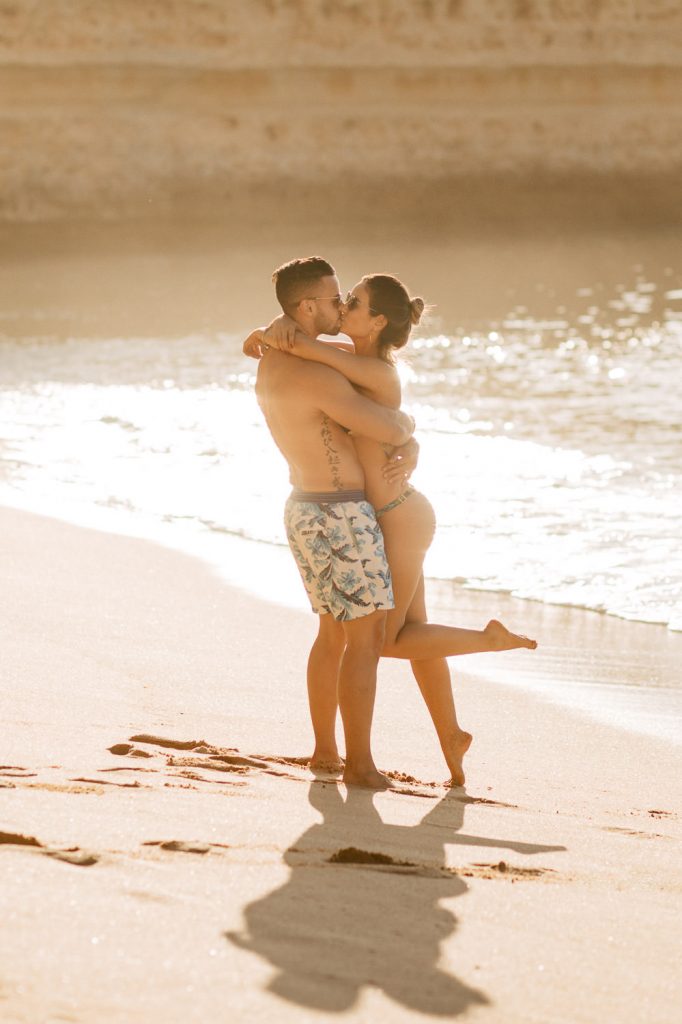 ensaio-praia-da marinha ela abraçando ele na beira do mar