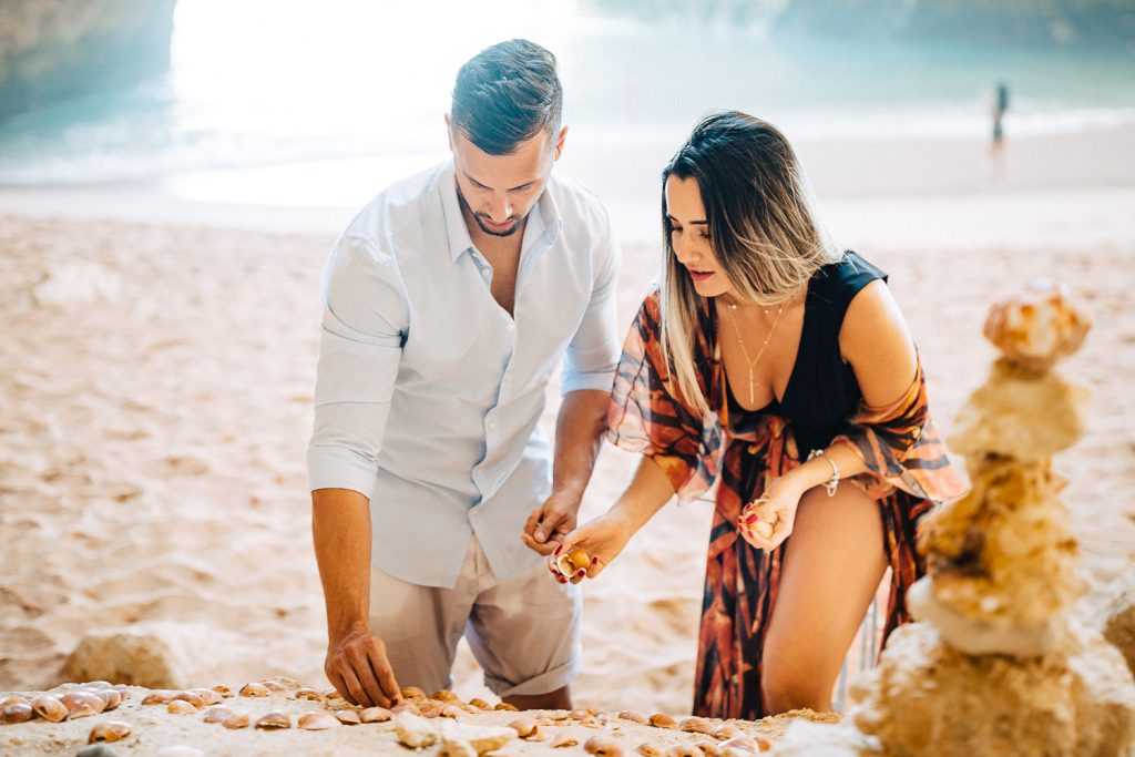 ensaio gruta benagil casal escrevendo com conchas