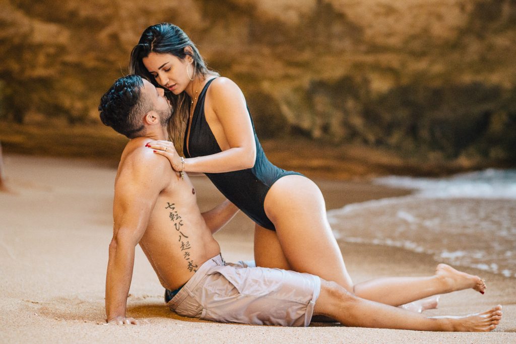 ensaio gruta benagil ele sentado na areia e ela de joelhos