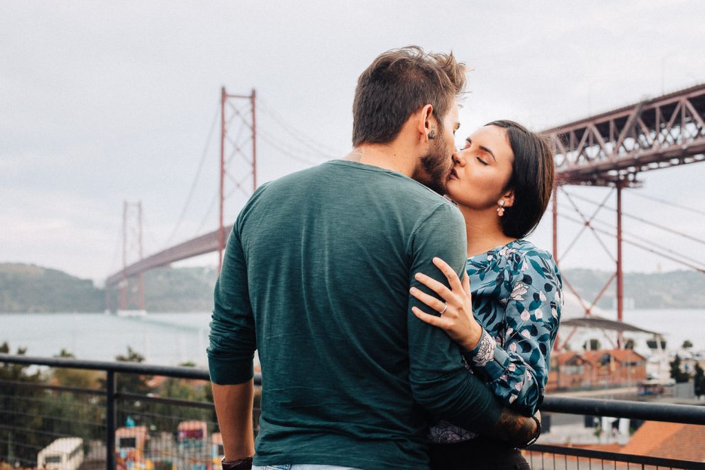 ensaio urbano lx factory lisboa casal se beijando com a ponte 25 de Abril no fundo