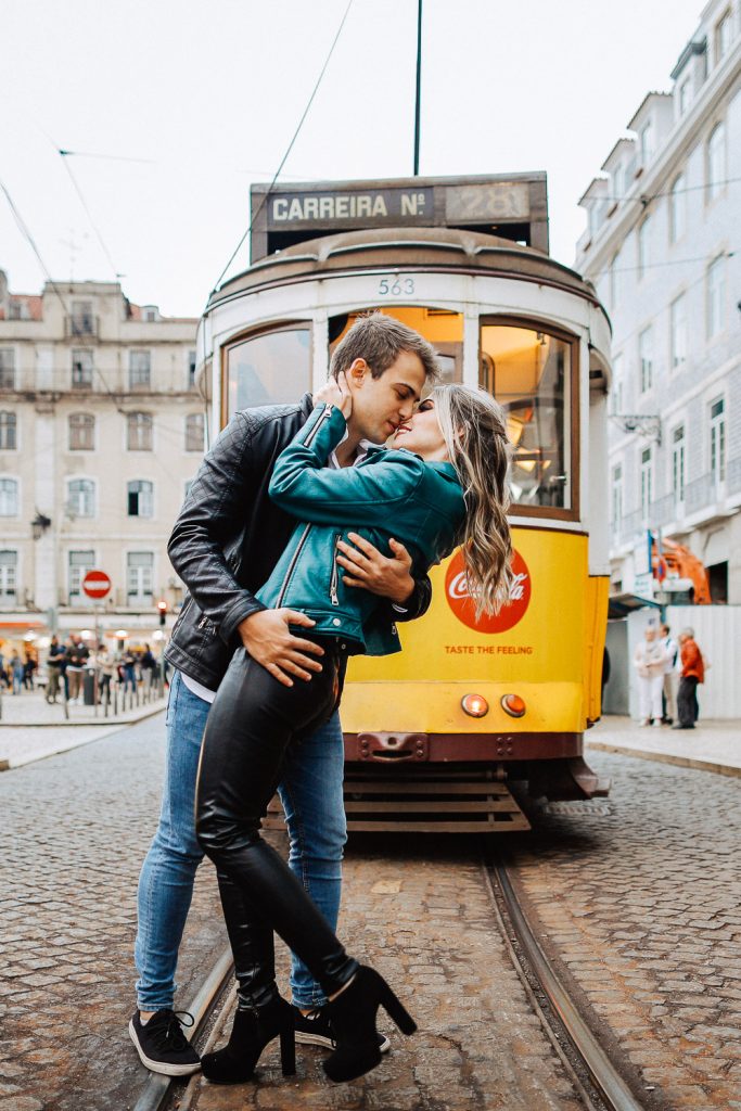 casal se beijando na frente do bondinho em Lisboa