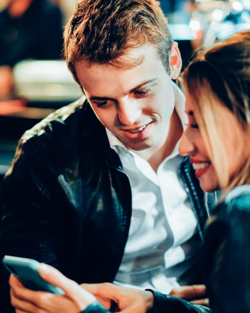 casal olhando para o celular dela no Hard Rock Cafe